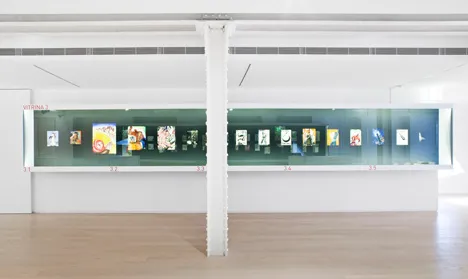 Długa szklana gablota w galerii z ilustracjami w środku
