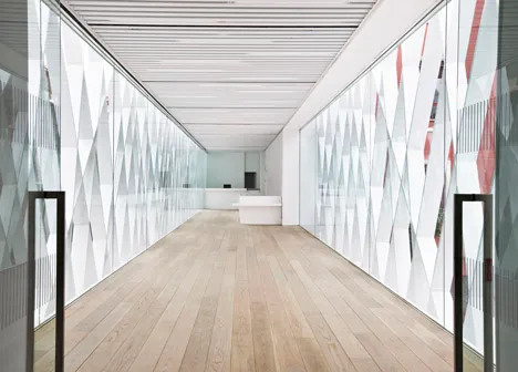 modern hallway with geometric white wall panels and light wood flooring