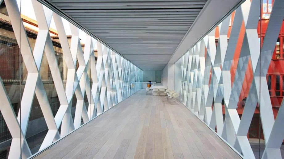 long corridor with geometric lattice walls and wooden floor
