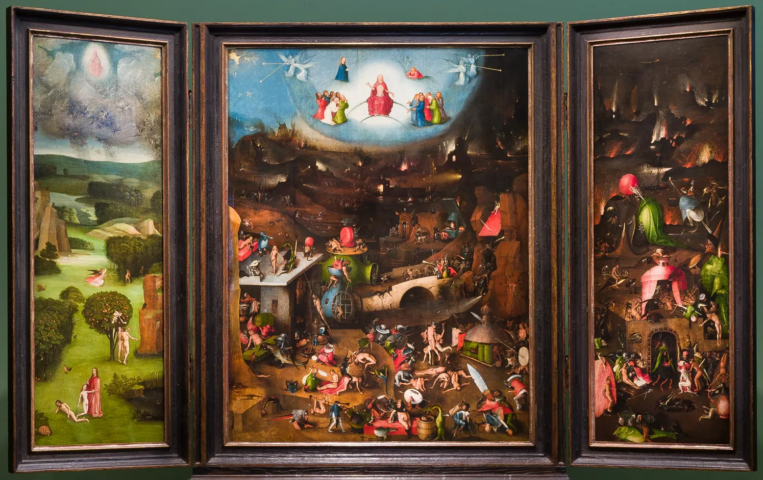 Triptych painting with three panels showing religious scenes, including a central panel with a celestial figure and a crowded landscape below, flanked by panels with figures in outdoor settings.