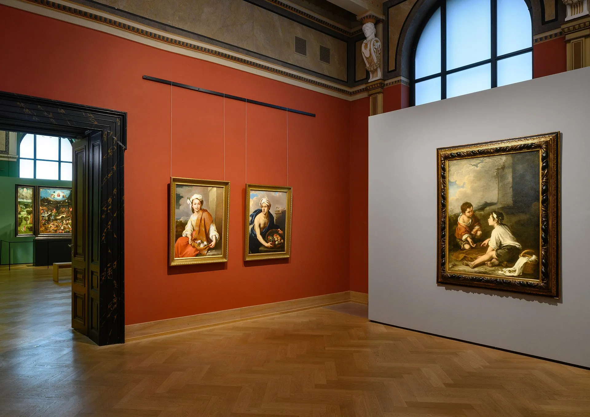 sala galerii z obrazami na czerwono-białych ścianach