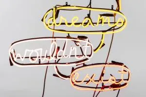 Neonowa instalacja artystyczna ze słowami dream, wouldn't i exist w świecących tubach