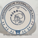 Okrągły emblemat Amsterdamsche Football Club Ajax przedstawiający lwa, tekst 'Amsterdamsche Football Club Ajax' i rok 1900