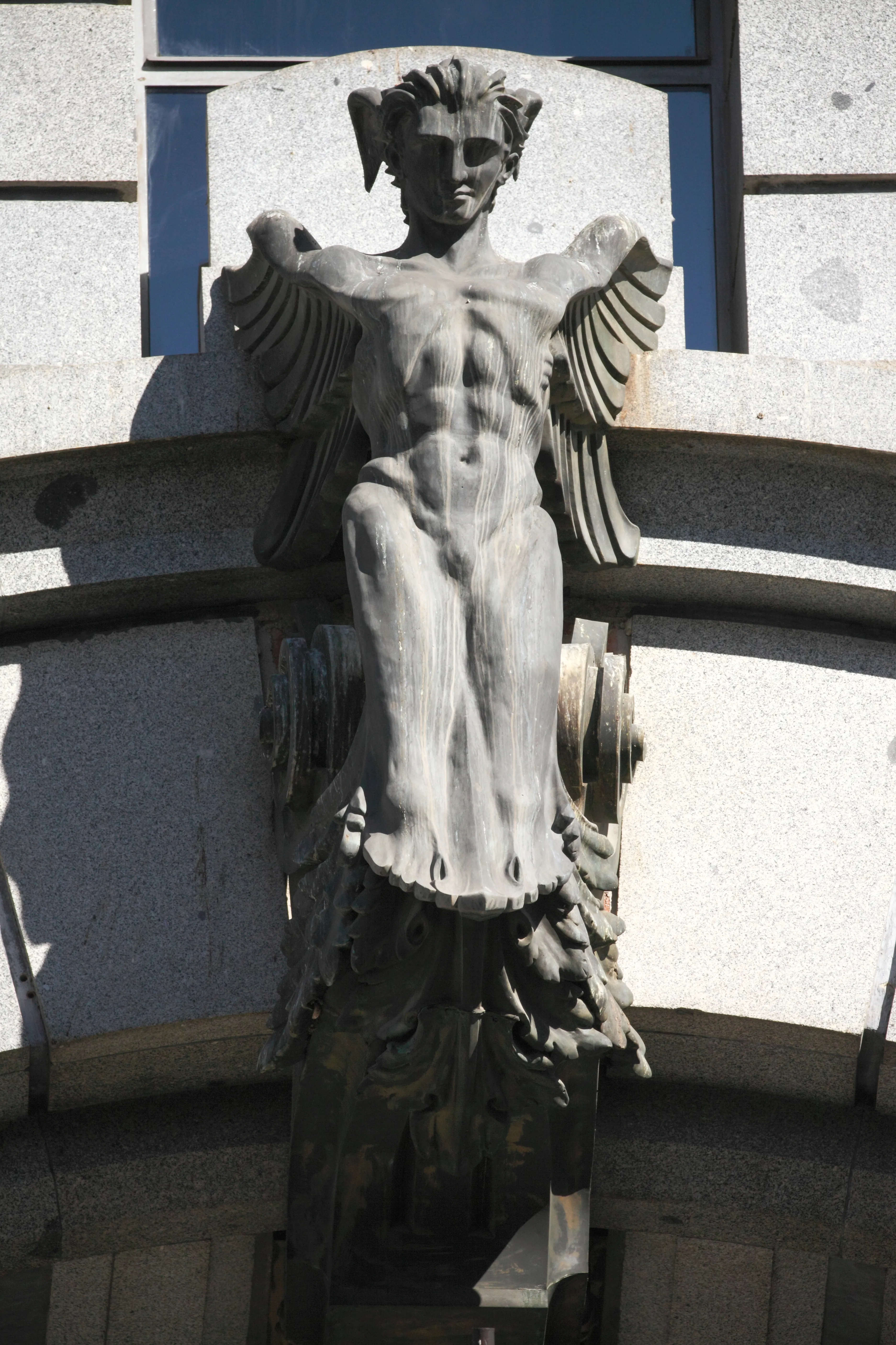 escultura de piedra de una figura alada en la fachada de un edificio