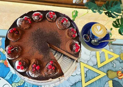 chocolate cake with truffles and berries next to a coffee cup