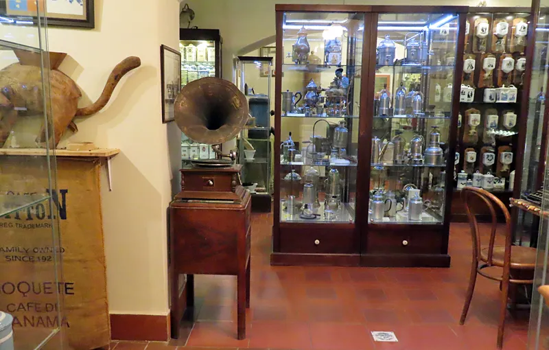 vintage coffee grinder and glass display cases filled with antique coffee-making equipment in a museum interior