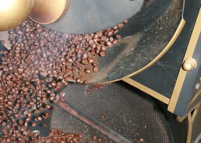 coffee beans pouring from a vintage roasting machine