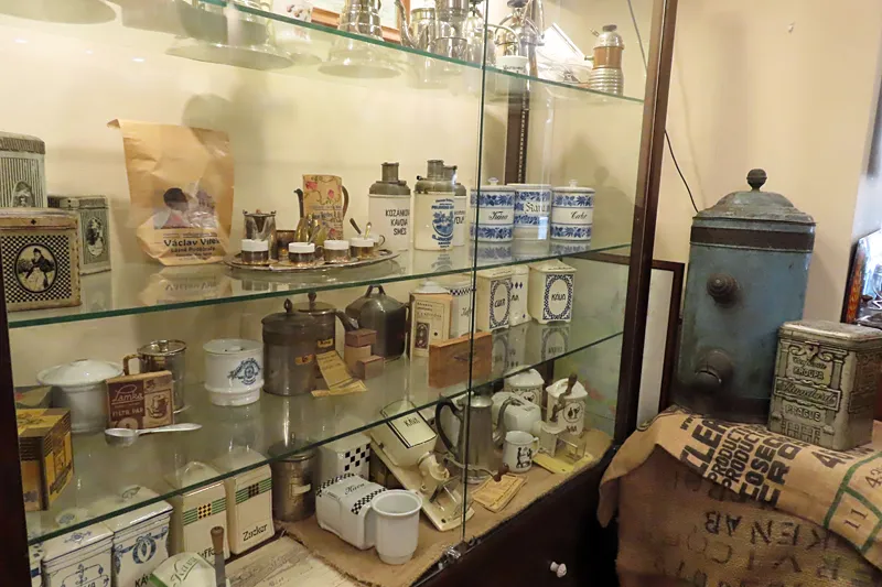 Glass display case filled with antique coffee-making equipment and containers