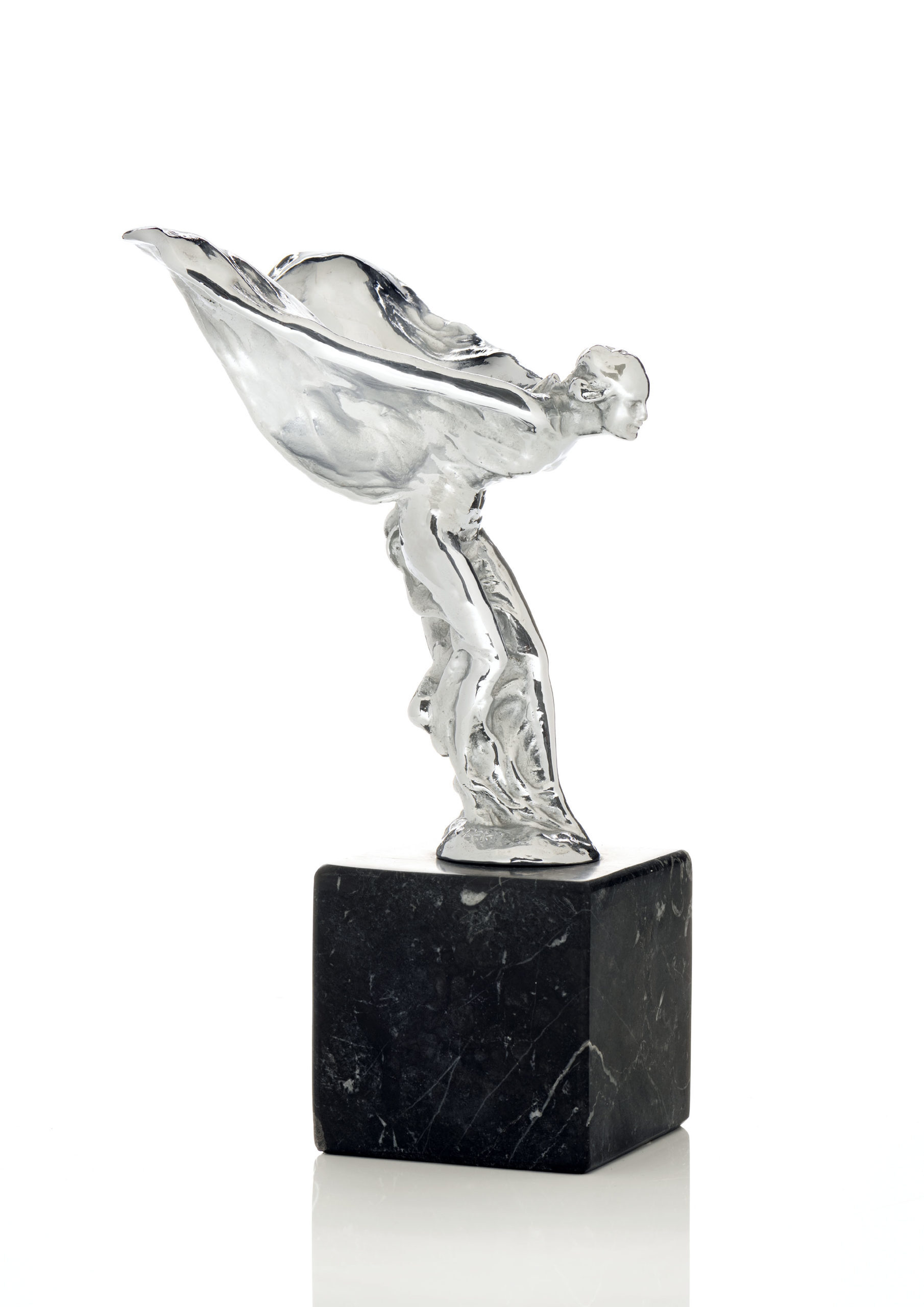 Heldere glazen sculptuur van een vrouwelijke figuur met vloeiende gewaden op een zwart marmeren sokkel tegen een witte achtergrond