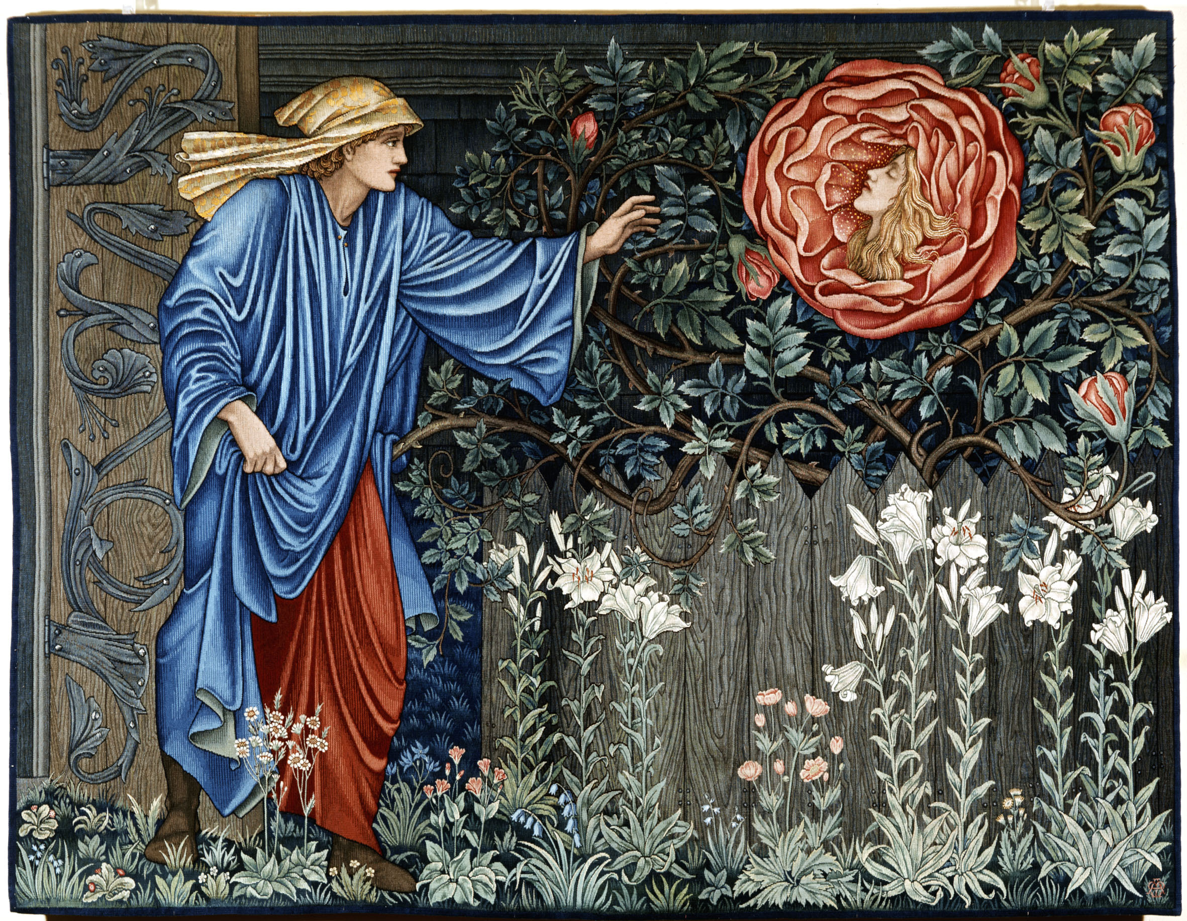 Vrouw in blauwe mantel en rode rok die zich uitreikt naar grote rode roos met een gezicht, omringd door bloemen en gebladerte, wandtapijt in Art Nouveau-stijl