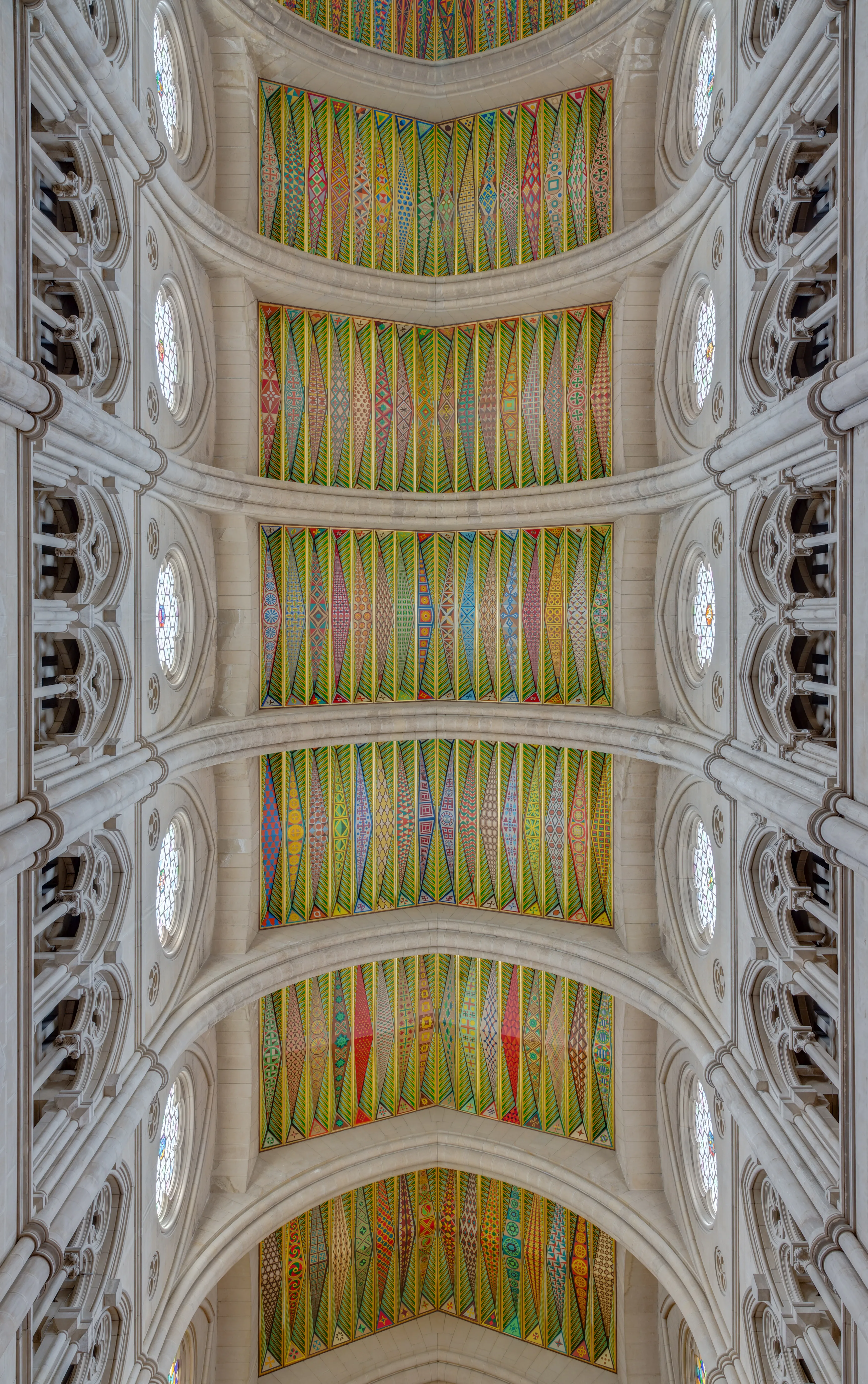 Interior view of the Almudena Cathedral with colorful geometric ceiling patterns and arched stone vaults