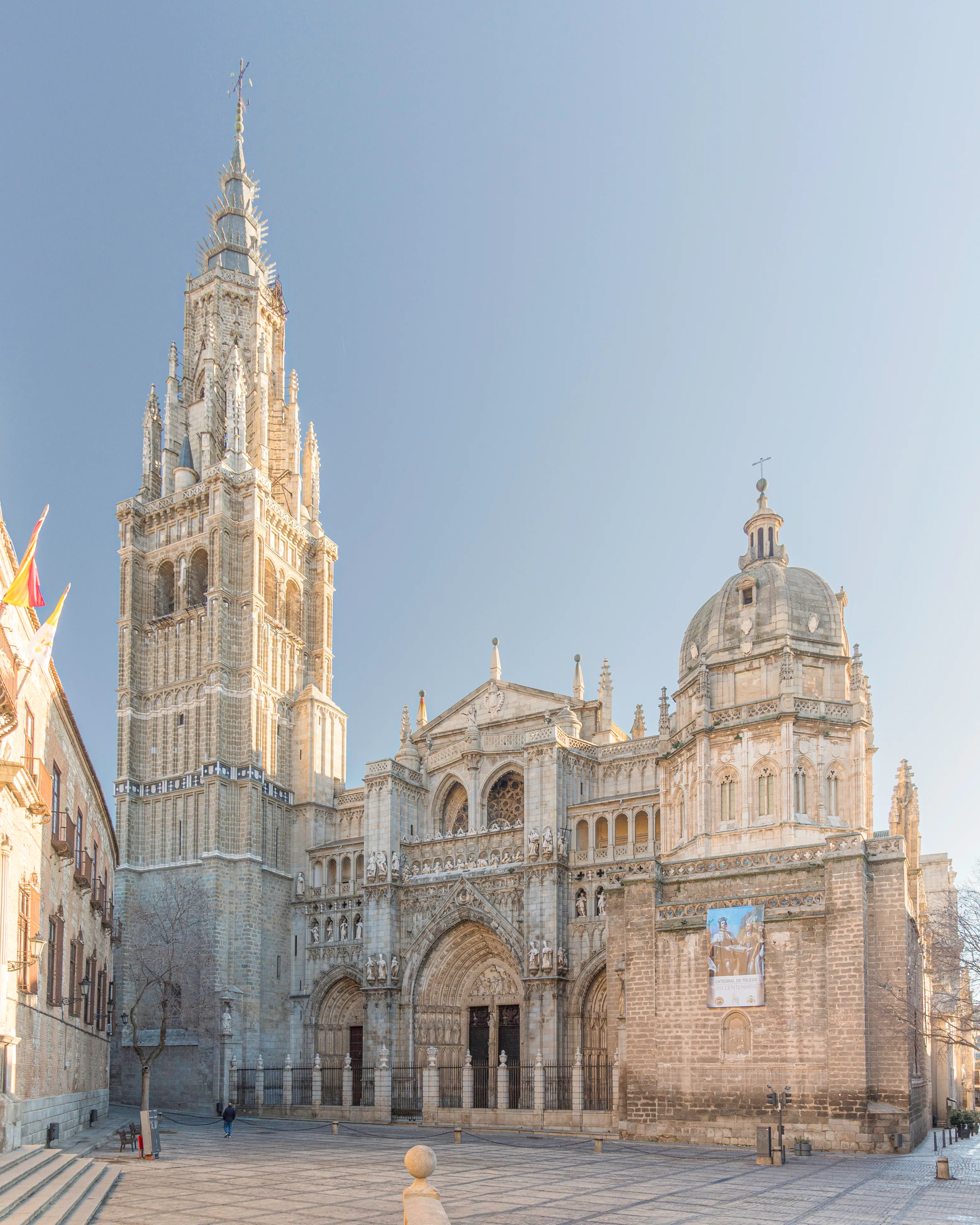 The Almudena Cathedral with its tall bell tower and dome under a clear blue sky