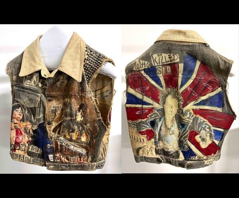 Zużyta dżinsowa kamizelka z kolorowymi naszywkami, w tym napisem 'Who Killed' i wzorem Union Jack, prezentowana na manekinach.