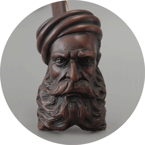 Pipa de madera tallada como una figura barbuda con turbante, con rasgos faciales detallados y barba texturizada