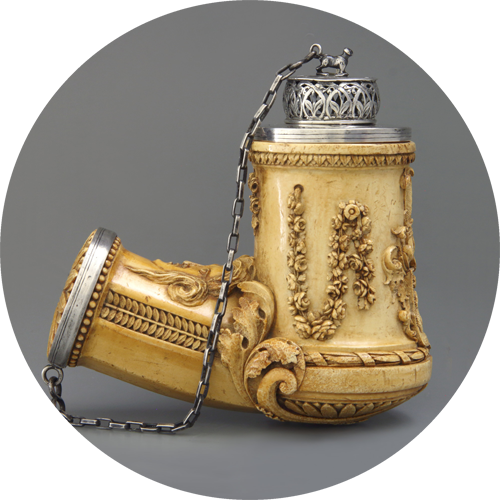 Ornate ivory smoking pipe with silver accents and chain, featuring floral carvings and decorative patterns