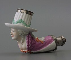Pipa de cerámica esculpida como una figura con un sombrero de copa blanco alto con banda plateada y túnica rosa, rasgos faciales detallados