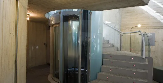 Interieur van Andén 0 - Ghost Station met een glazen lift, betonnen trappen en houten muren