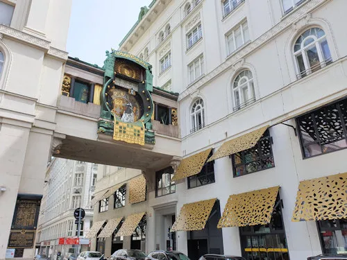Art Nouveau klokbrug met gouden details die een straat tussen gebouwen overspant