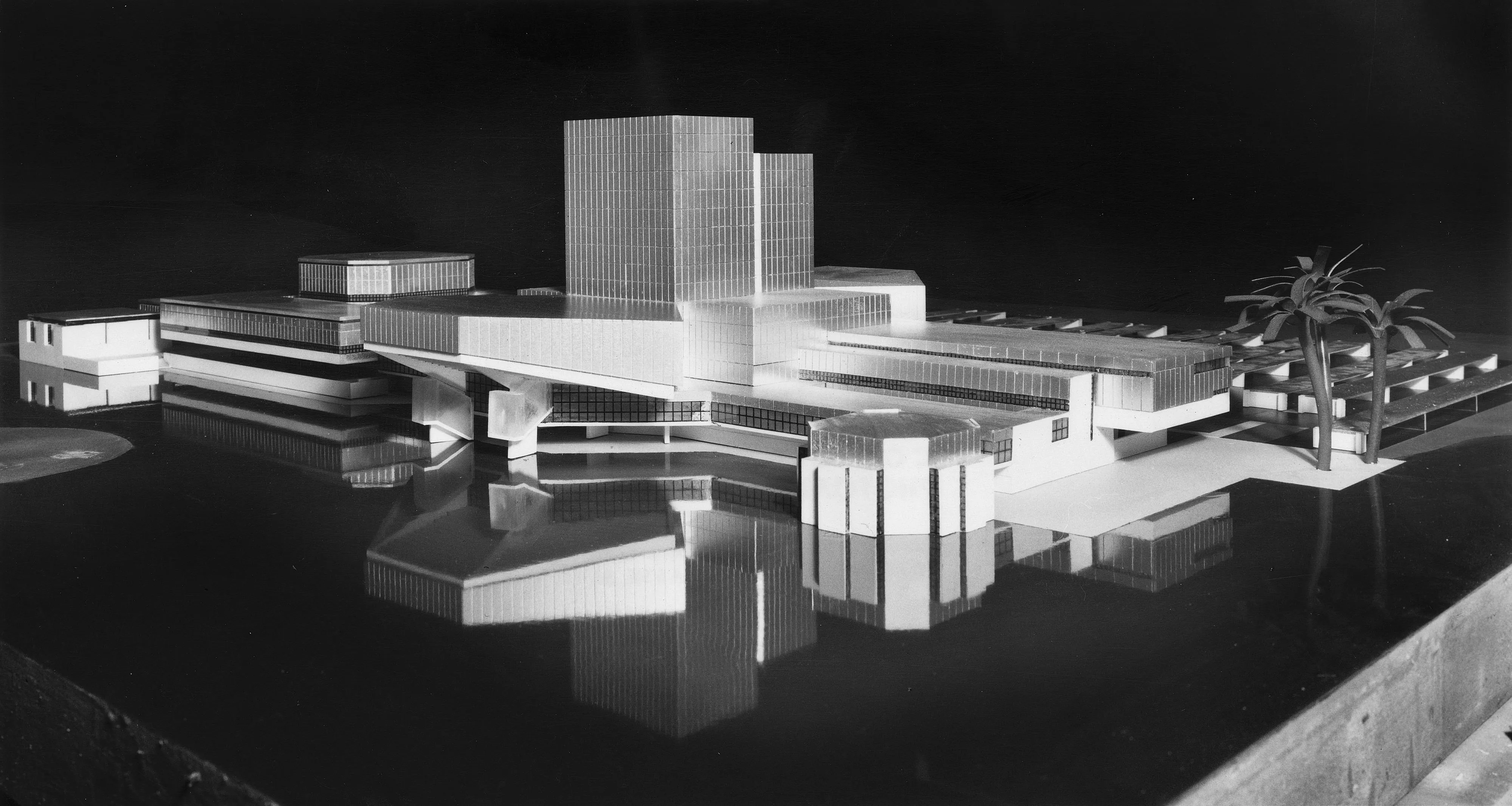zwart-wit architectuurmodel van een modern wooncomplex met geometrische vormen en een reflecterend oppervlak