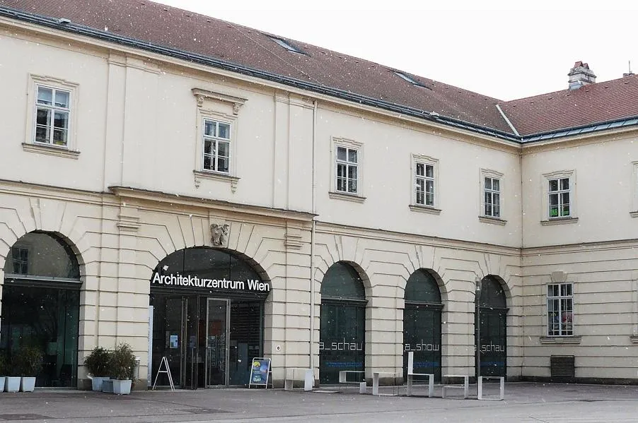 Beige building with arched windows and entrance, sign reading Architekturzentrum Wien