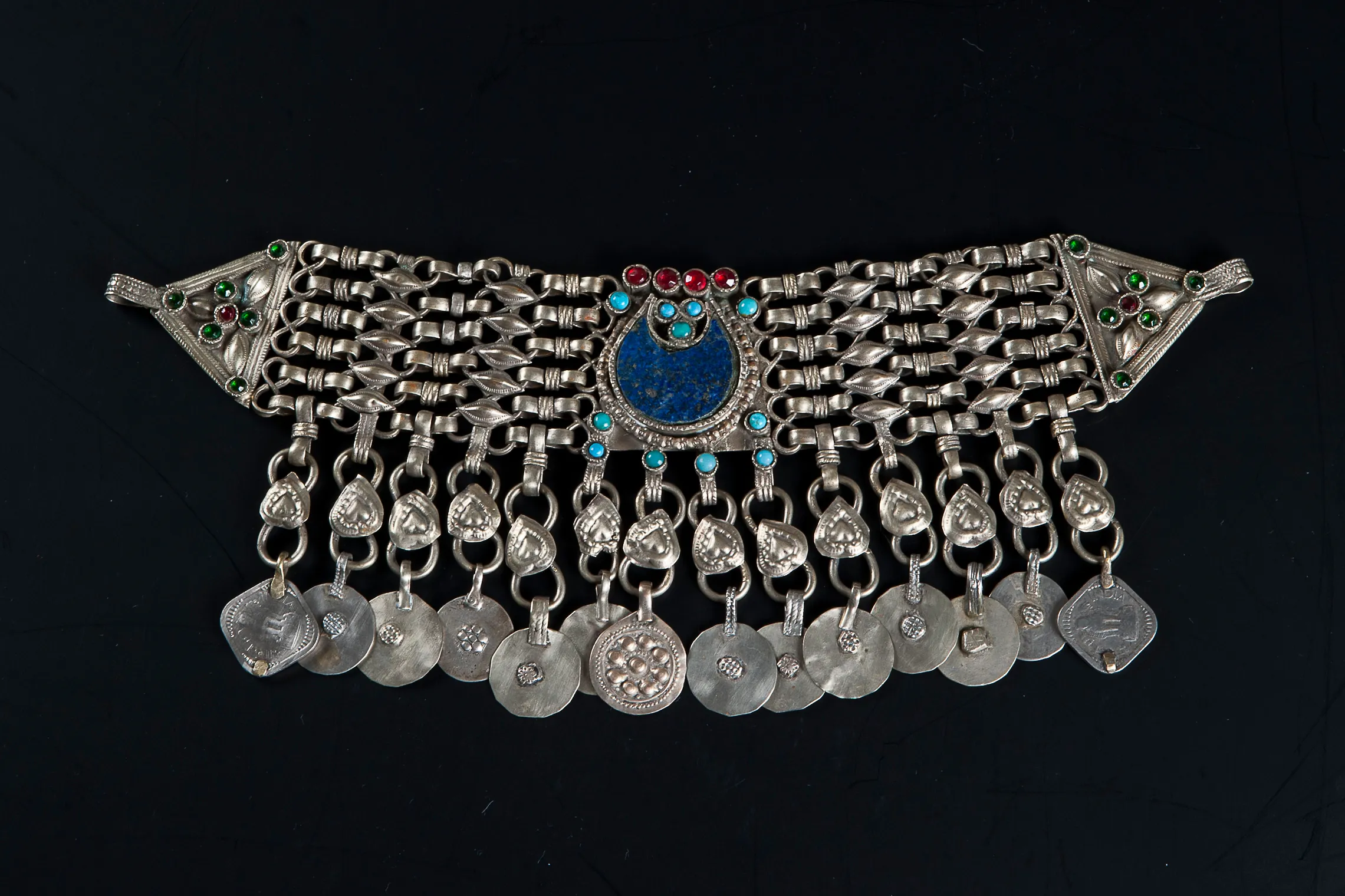 collar de plata con piedras azules y verdes y piezas de metal colgantes
