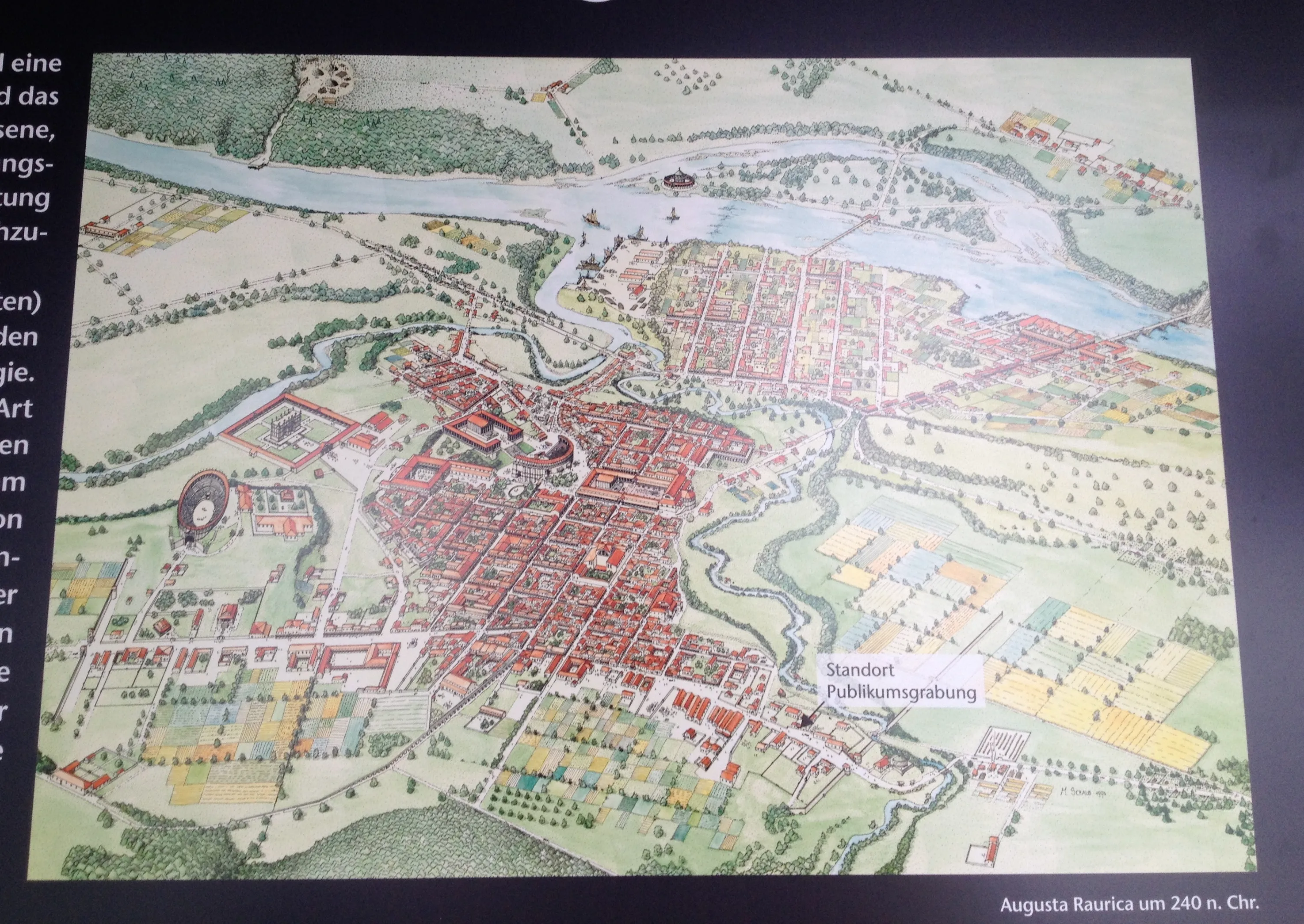 Historische reconstructiekaart die de indeling van de Romeinse nederzetting Augusta Raurica rond 240 n.Chr. toont, met rode bouwblokken, stratenpatronen, een amfitheater en de bocht van de Rijn.