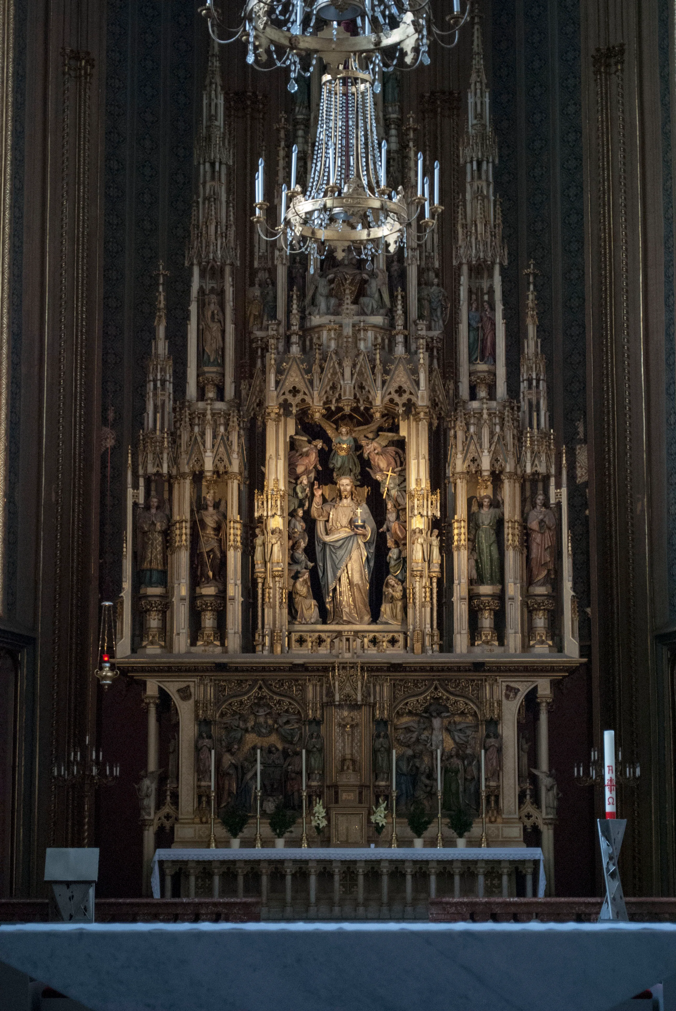 Gothic high altar with religious statues and a chandelier in the Church of the Augustinian Friars