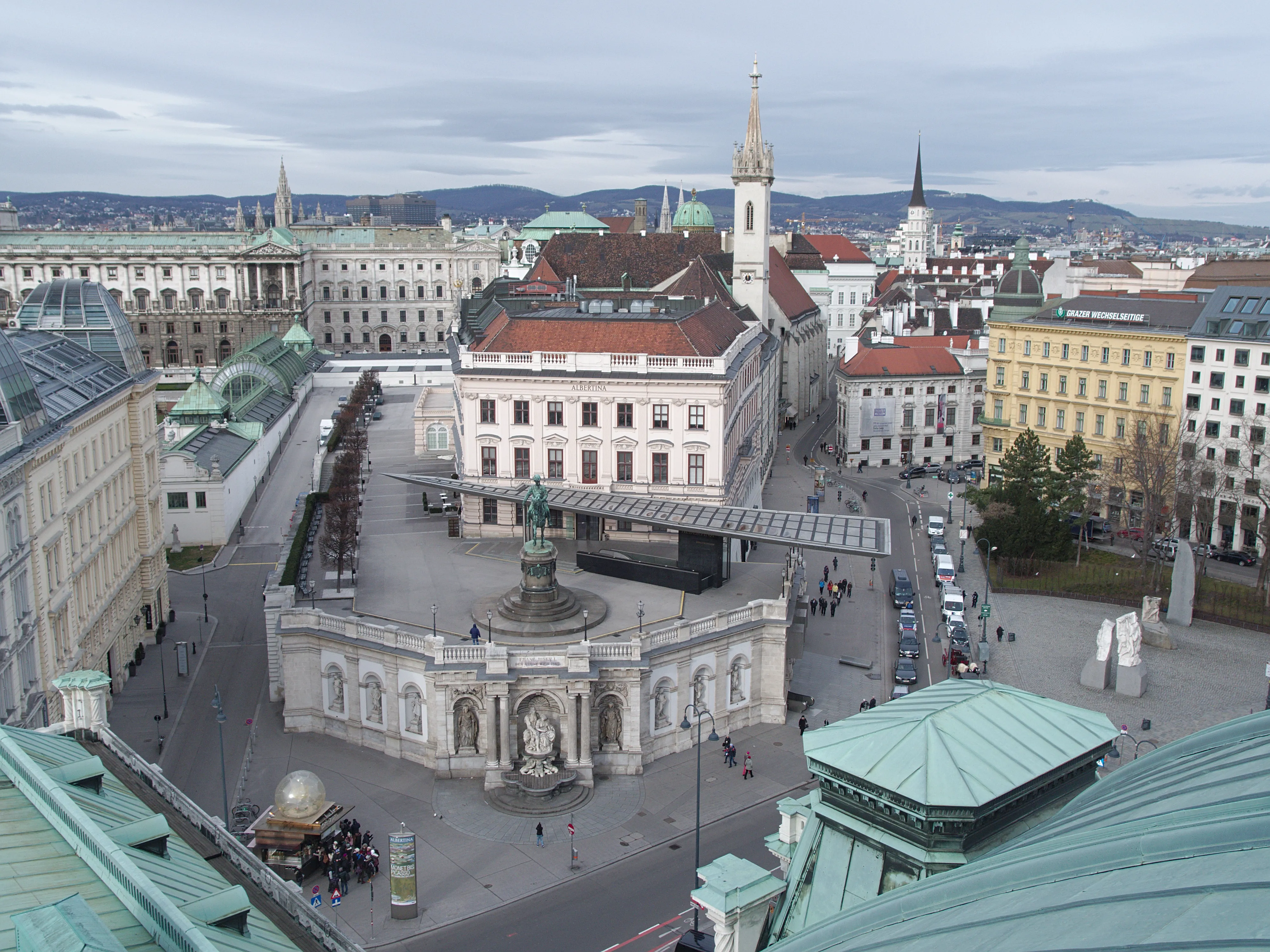 Aerial view of the Church of the Augustinian Friars with its distinctive spire and surrounding buildings in Vienna.