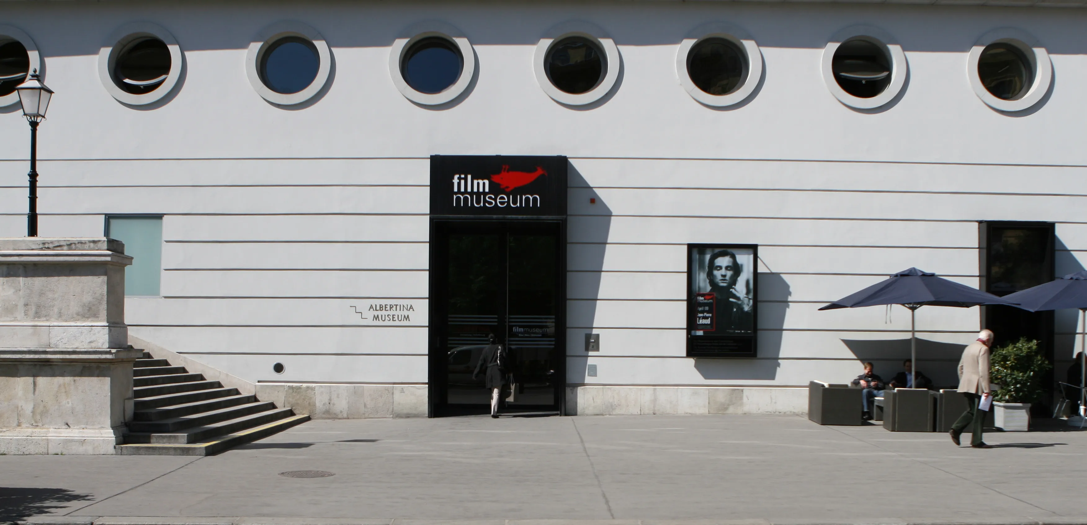 White building with circular windows and a black sign reading 'film museum' above the entrance