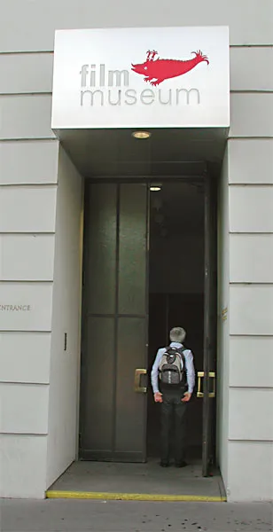 Entrance to the Austrian Film Museum with a sign displaying 'film museum' and a red bird logo above the door