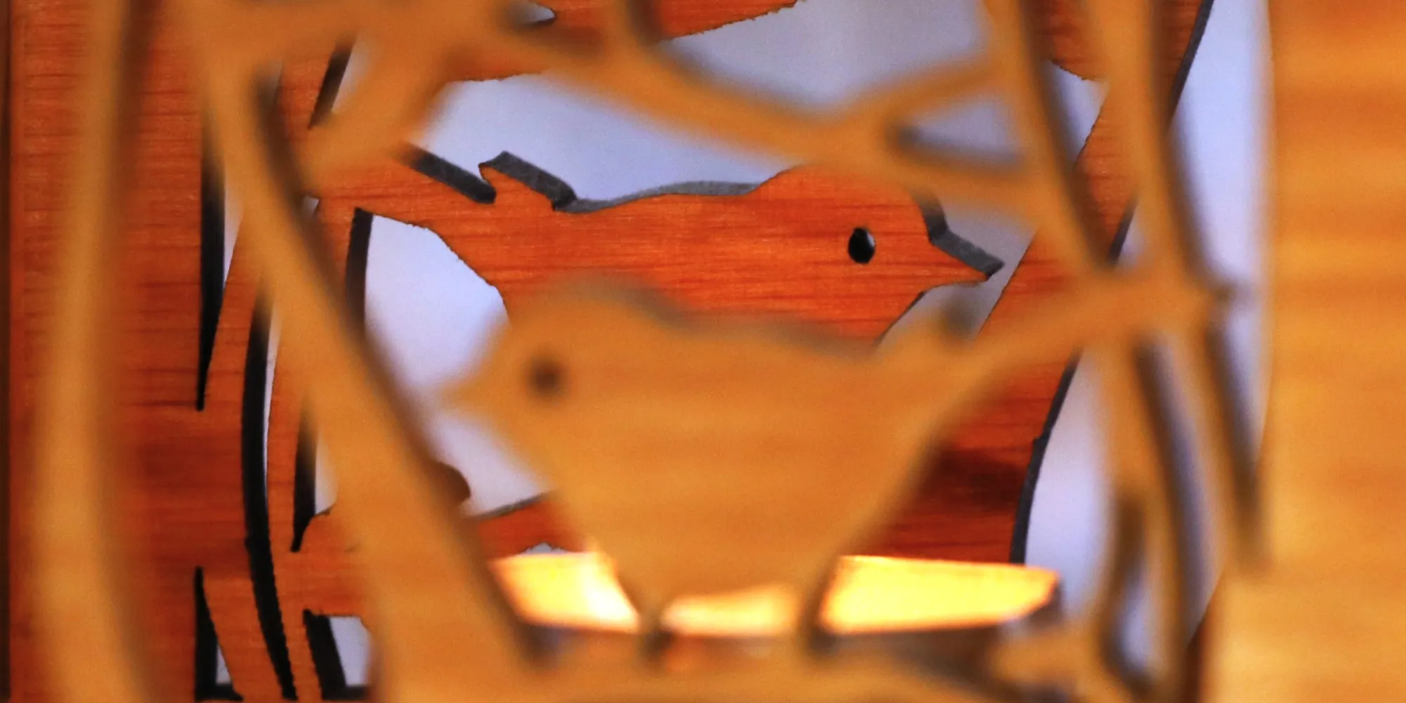talla de madera de una silueta de pájaro con ramas