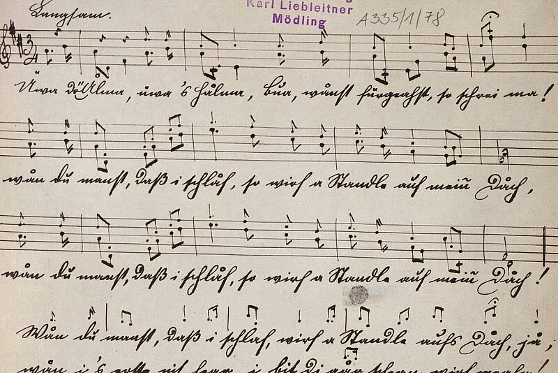 Partitura musical escrita a mano con notación de música y texto en alemán