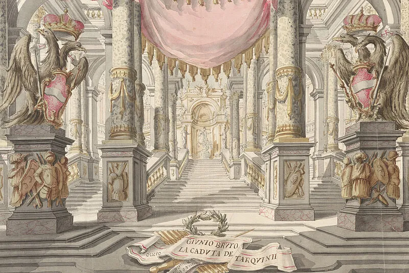 salón ornamentado con columnas de mármol, águilas esculpidas y cortinas rosas