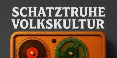 Texto blanco 'SCHATZTRUHE VOLKSKULTUR' sobre una grabadora de cinta vintage con carretes rojos y verdes sobre una base naranja