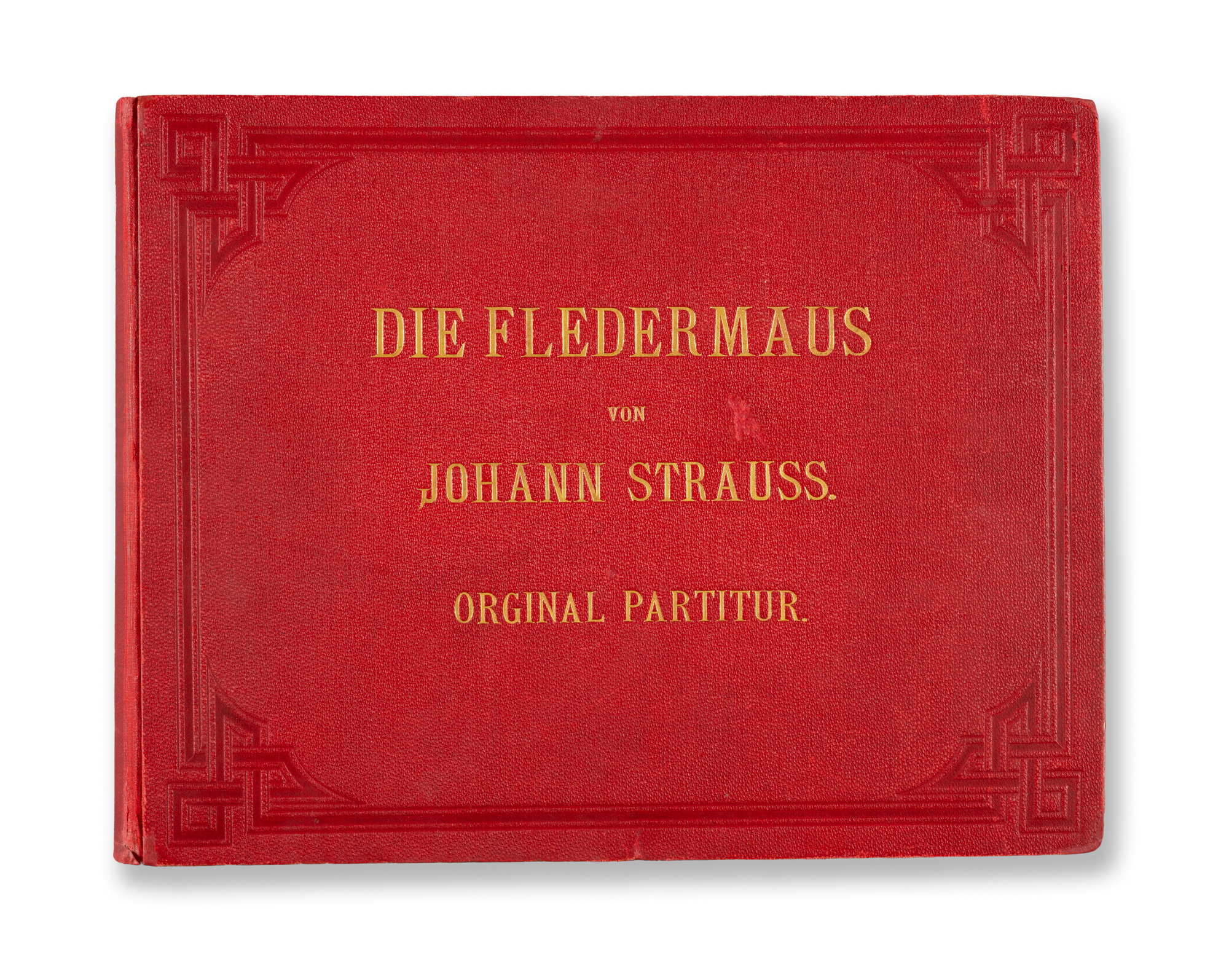 Czerwona okładka książki ze złotym napisem 'DIE FLEDERMAUS VON JOHANN STRAUSS. ORGINAL PARTITUR.'