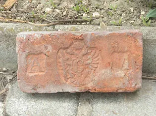 rode baksteen met reliëf leeuwenwapen en de letters A en M