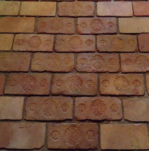close-up of a brick wall with embossed patterns and symbols on individual bricks
