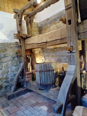 wooden brick press machine in a stone-walled room