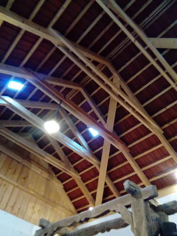 Exposed wooden beams and a red-tiled ceiling inside a building