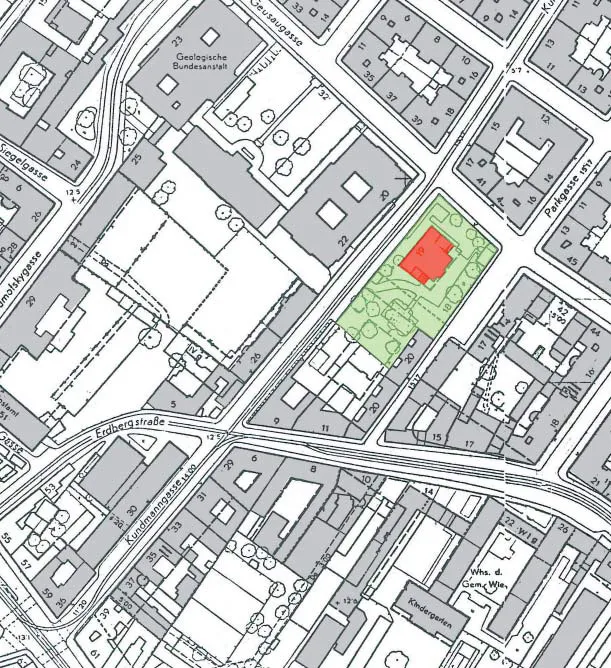 Un mapa que muestra un edificio resaltado en rojo dentro de un área verde, rodeado de calles y otras estructuras.