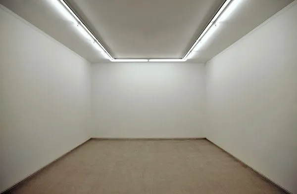 Empty white gallery room with fluorescent ceiling lights and beige floor