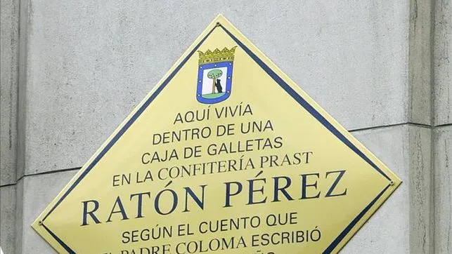 Señal de diamante amarillo con texto en español sobre el Ratón Pérez y la Confitería Prast en una pared de piedra