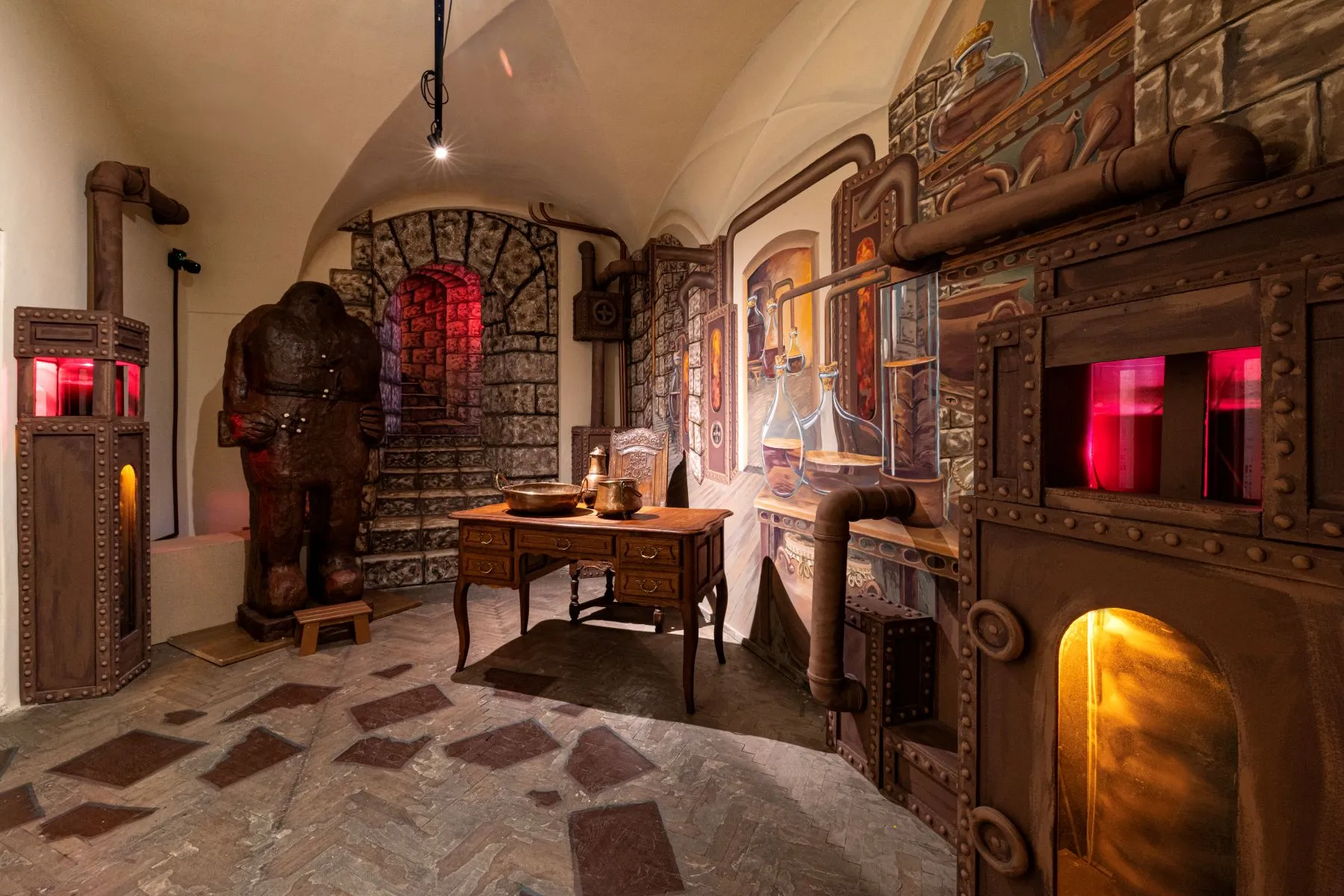 Interior of Choco Art Museum with stone walls, wooden furniture, and chocolate-themed sculptures under warm lighting