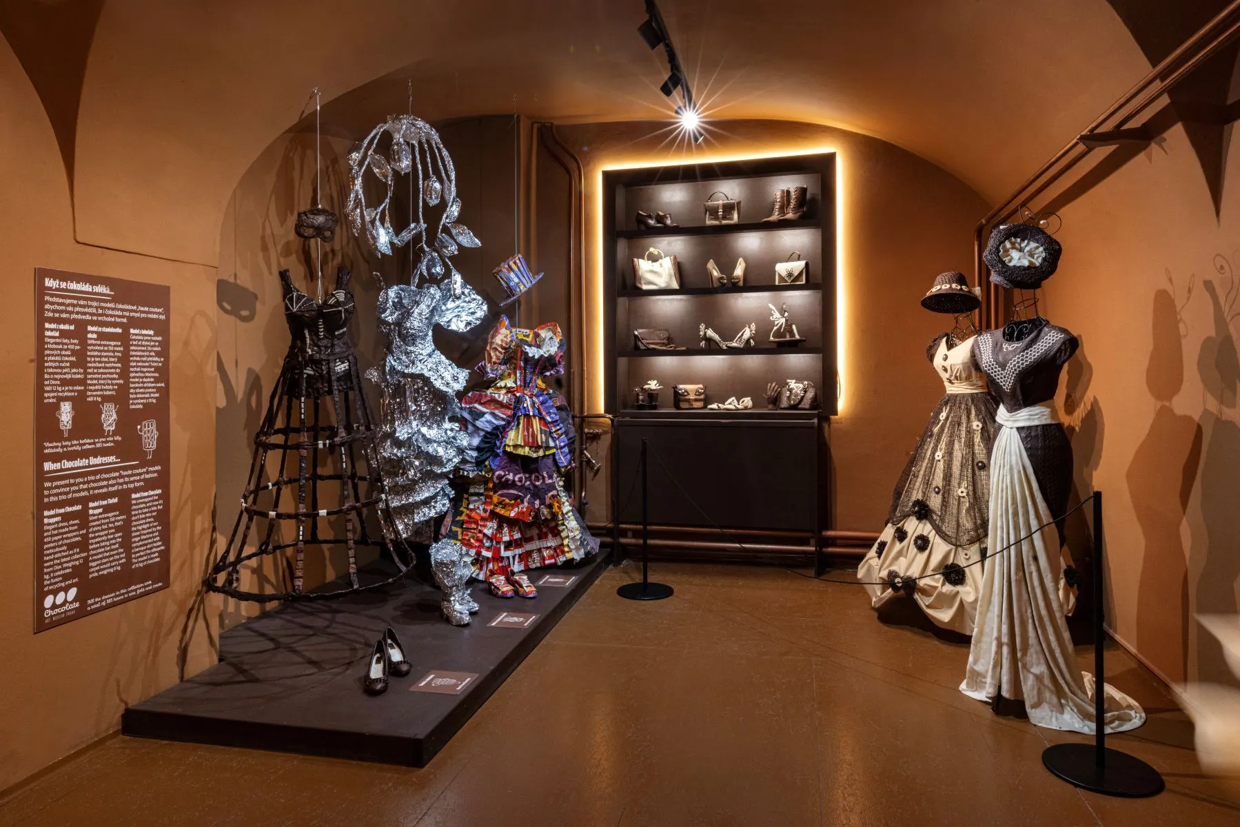 Chocolate sculptures and mannequins in a museum gallery with warm lighting
