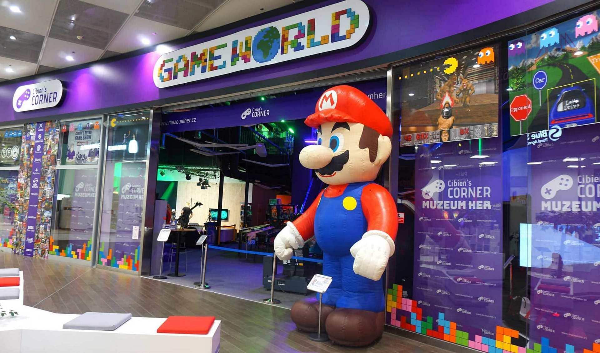 Large inflatable Mario figure standing outside a building with a purple facade and 'GAME WORLD' sign above the entrance.
