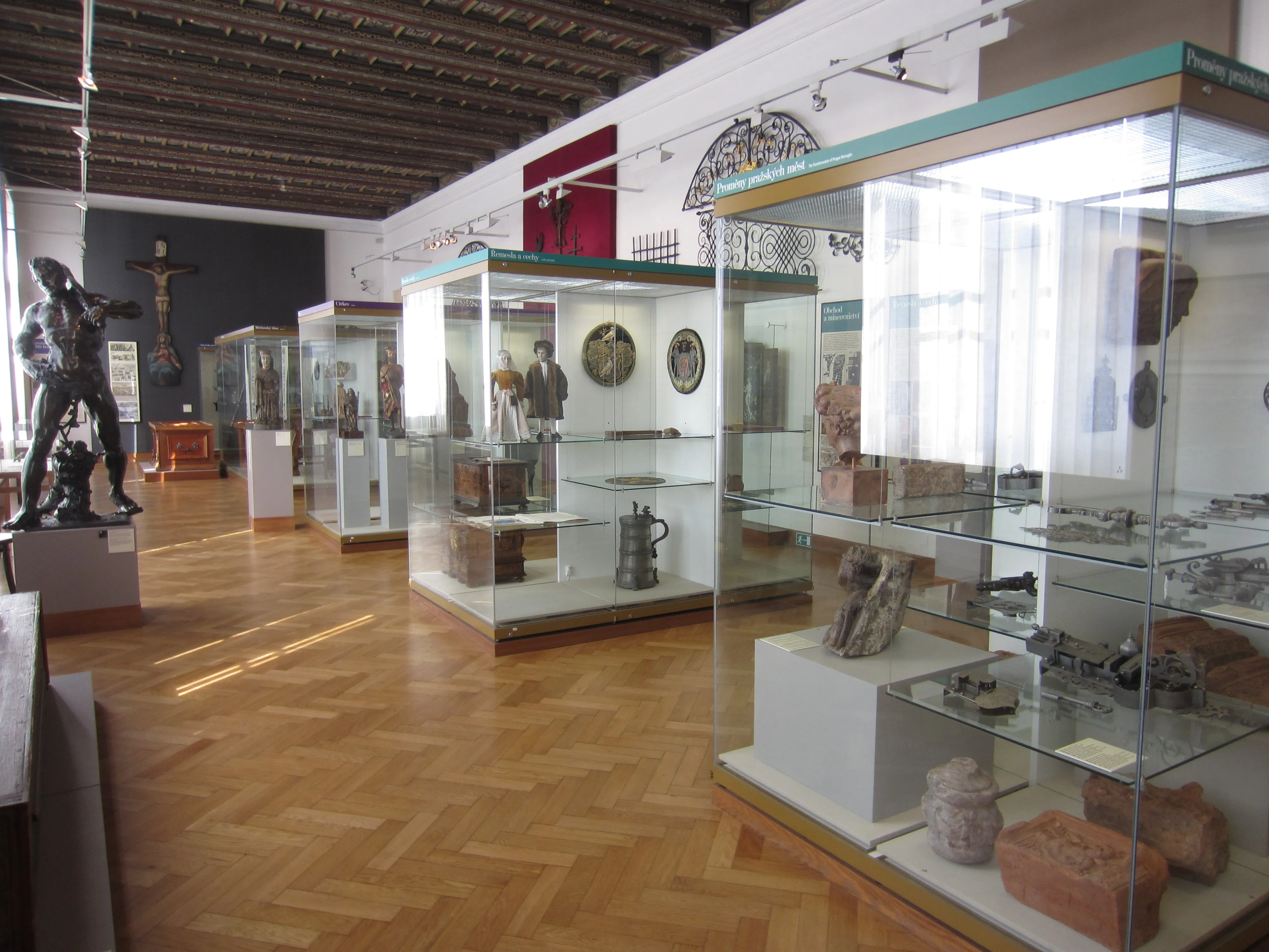 museum gallery with glass display cases, wooden floors, and a large sculpture