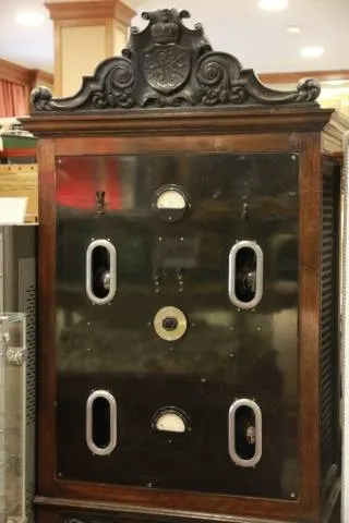sierlijk houten kabinet met glazen panelen en cirkelvormige wijzerplaten, met daarin een vintage radiotelegrafieapparaat