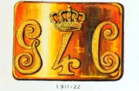 Gouden embleem met een kroon boven de letters G en C met sierlijk krullend werk en de tekst 1.911-22 eronder
