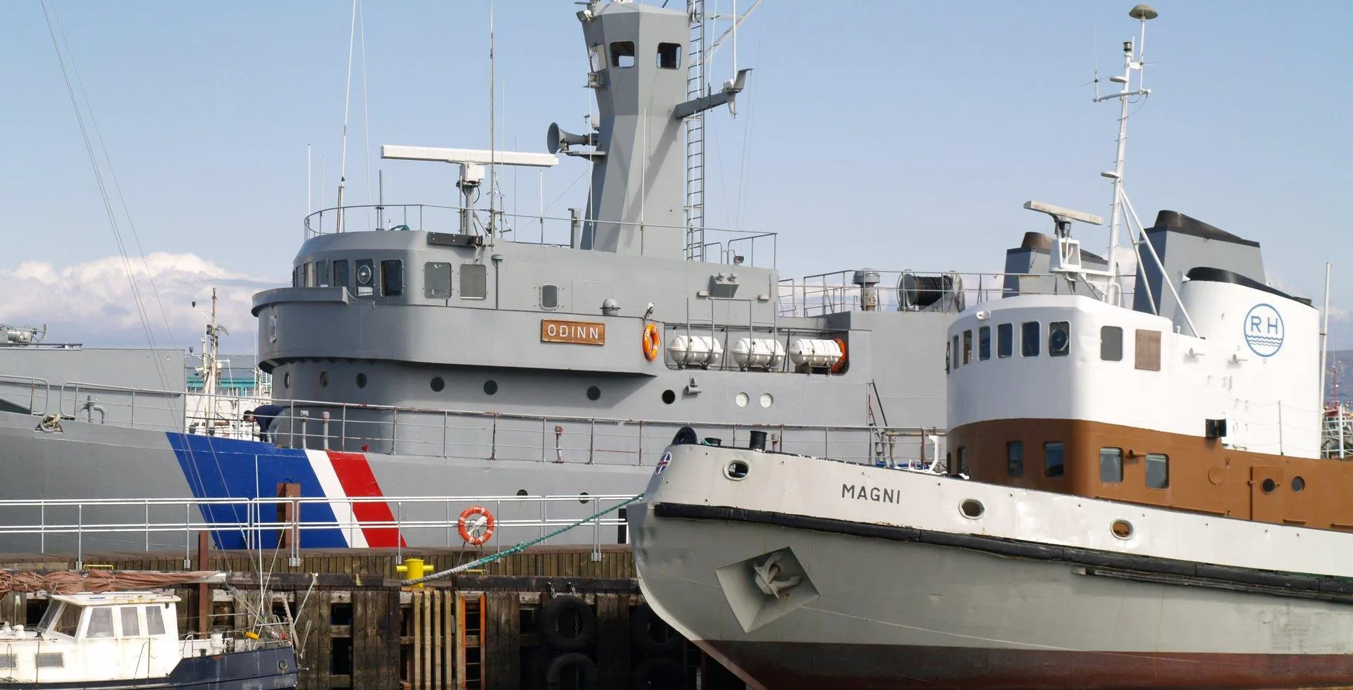 El buque gris de la Guardia Costera Óðinn estaba atracado en un puerto junto al buque más pequeño de color blanco y marrón Magni