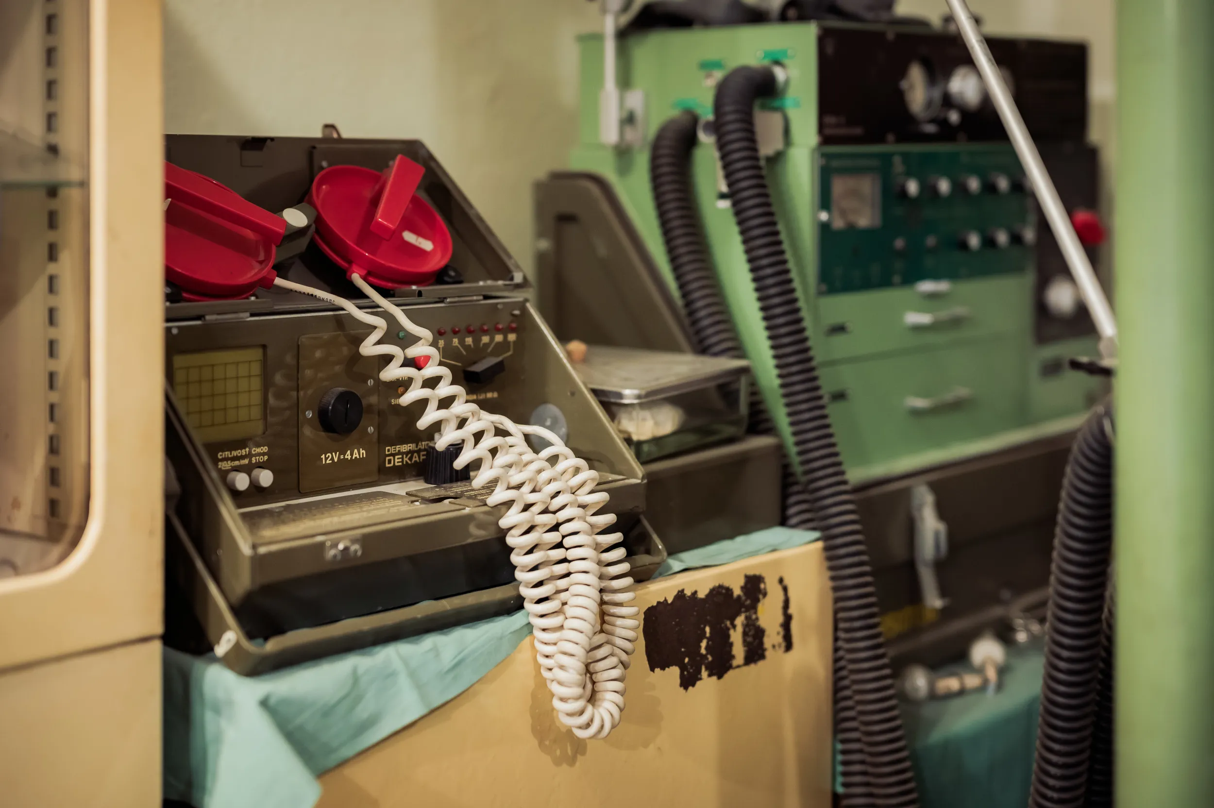 vintage communication equipment with red telephone and coiled cord in a museum display